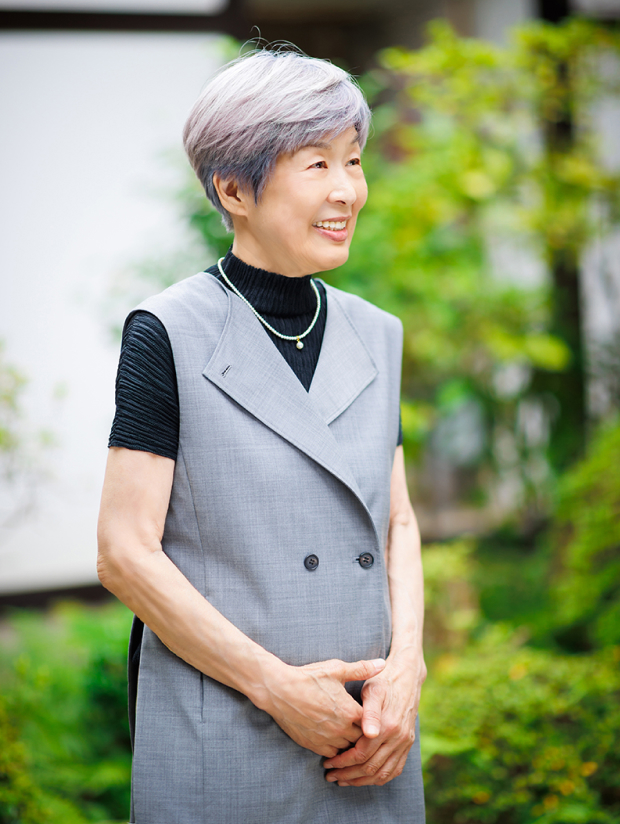 画像：庭に佇む笑顔の女将